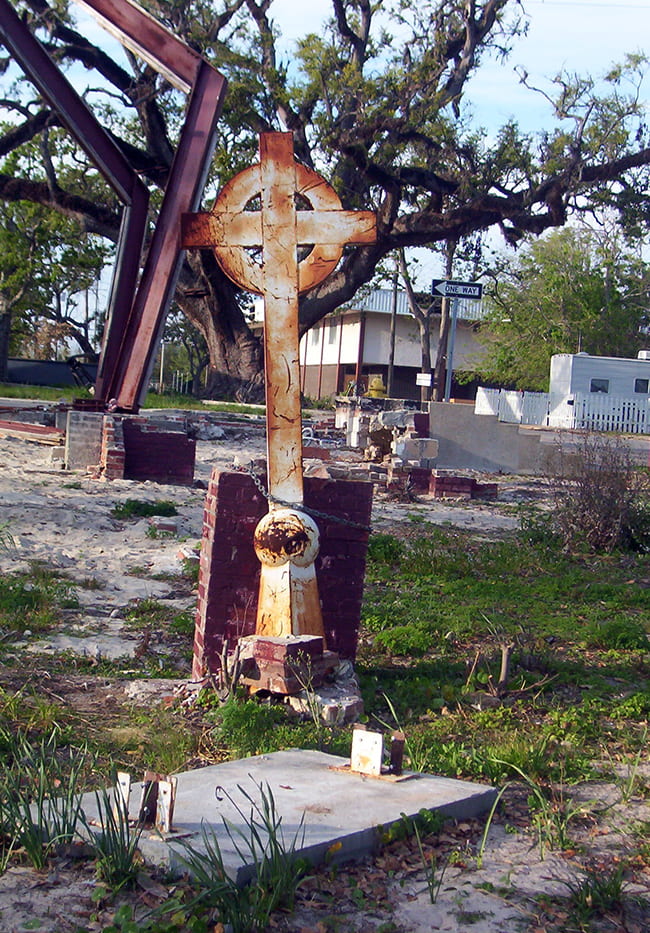 Rusty cross left standing in damages building site