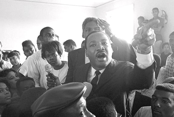 MLK speaking from the center of a crowd