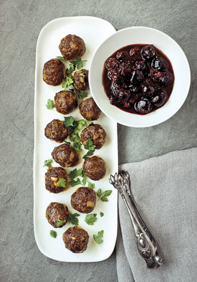 Syrian Meatballs on a plate with a bowl of sauce