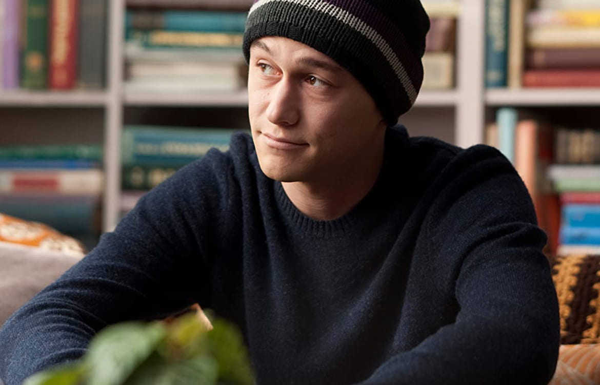 Young man wearing a knit cap looking thoughtfully off to the side