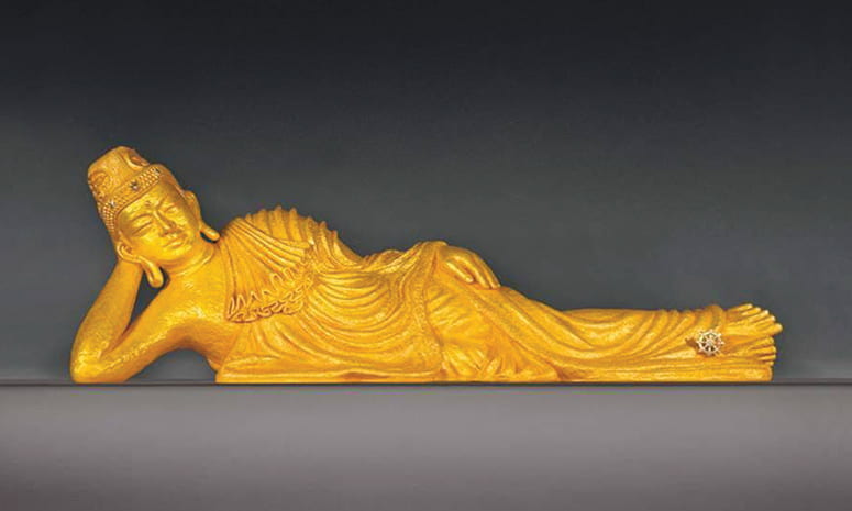 Gold figure of a reclining Buddha
