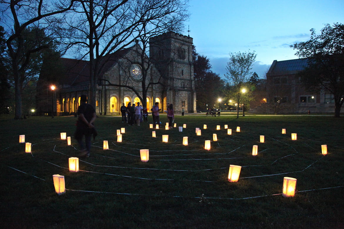Photo of luminary lights on a campus green with students