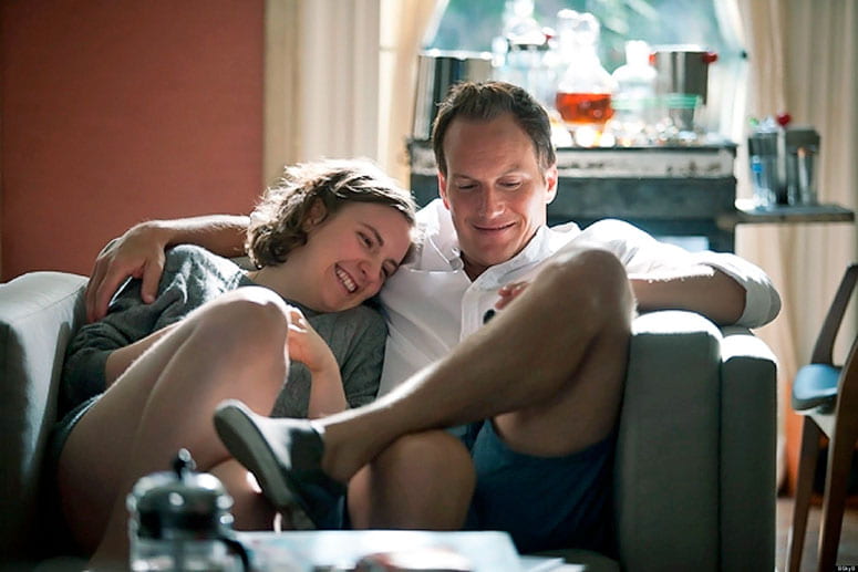 Film still from Girls of a happy couple snuggling on a couch reading