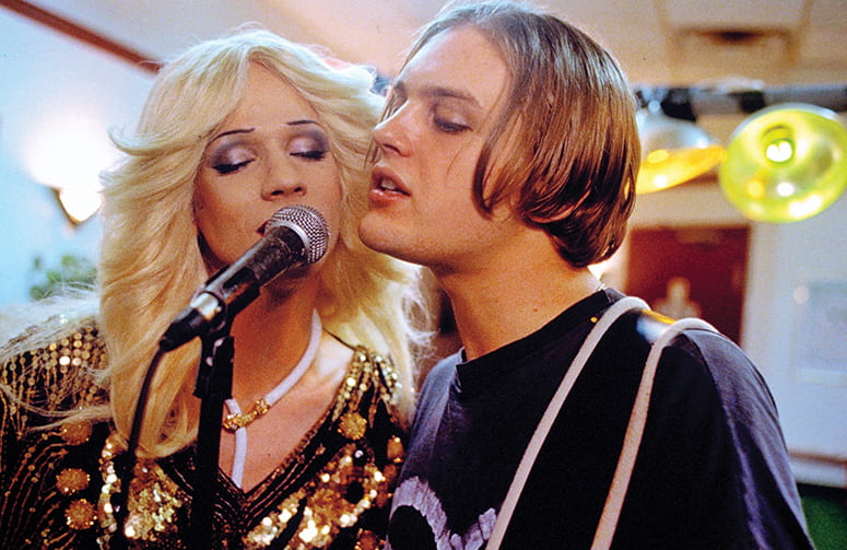 Film still of two singers together at a microphone
