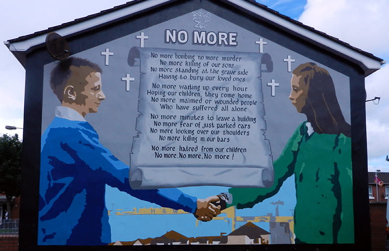 Mural showing a boy and girl shaking hands with the text of a poem titled No More behind them