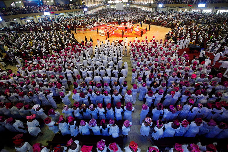 Photo of a congregation of thousands of people worshipping in a Nigerian megachurch