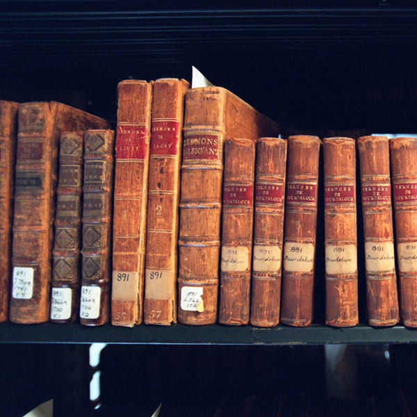 Photo of old books of sermons on the library shelves