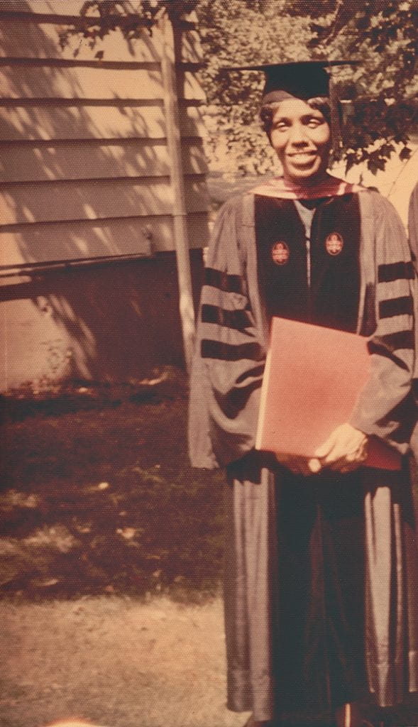 Karefa Smart in her graduation robes, holding her degree certificate