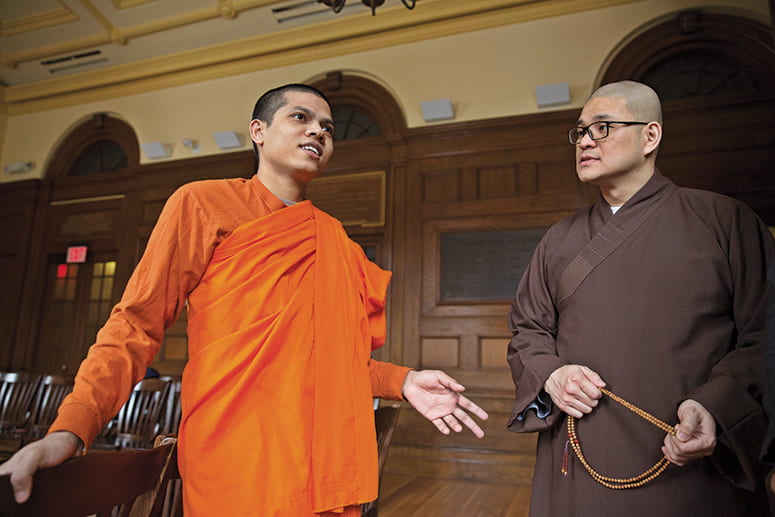 Two Buddhist monks standing in the chapel of Divinity Hall