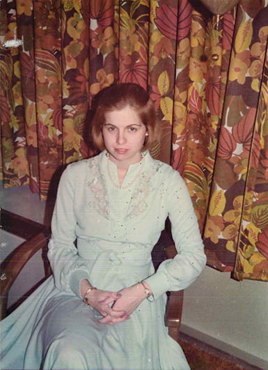 Snapshot of a young woman in a dress sitting in a chair