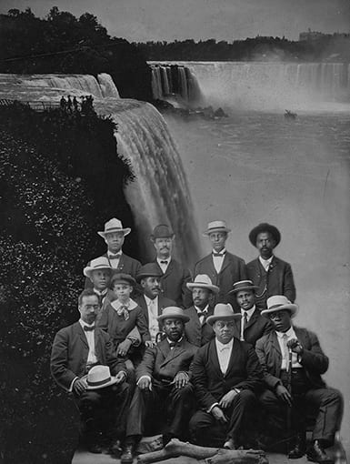 Photo of a group of African American men infront of a background showing Naigara Falls