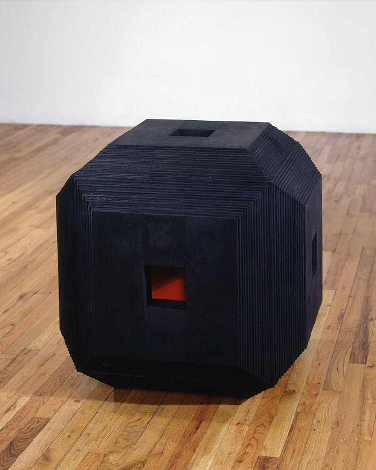 Photo of a black cube with a small opening to see a red interior