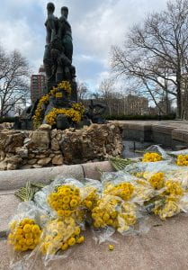 Bouquets of yellow flowers decorating a statue and left in front of it for people to take away