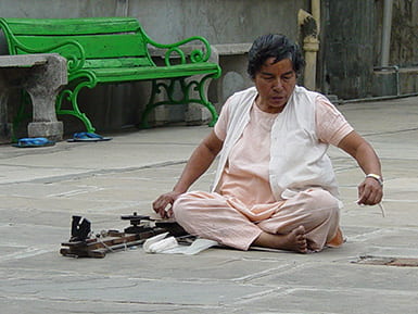 Woman sitting on the floor spinning thread