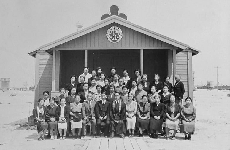 Historic photo of a large group posing outside a Buddhist church building