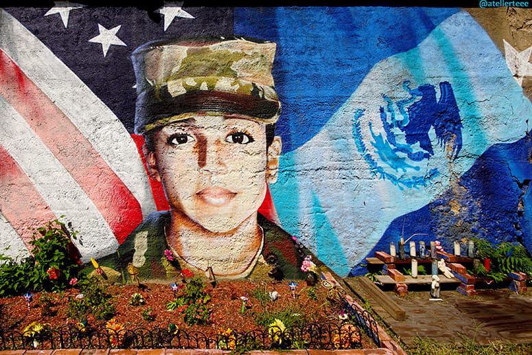 Street mural of Guillen with candles and flowers